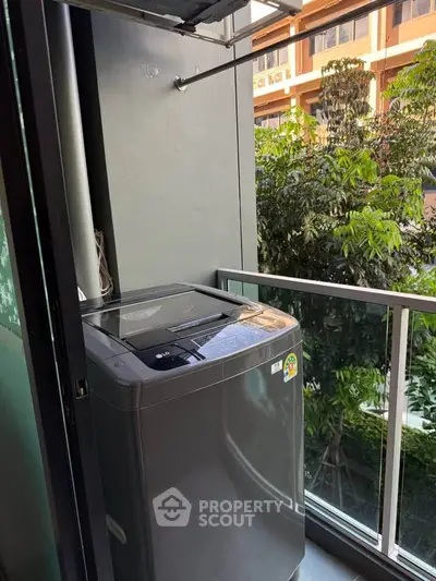 Modern balcony with washing machine and lush green view