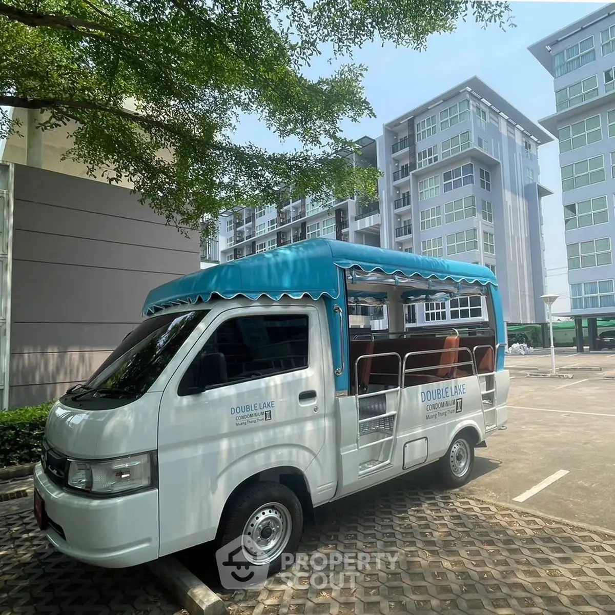 Modern residential complex with shuttle van in sunny parking area