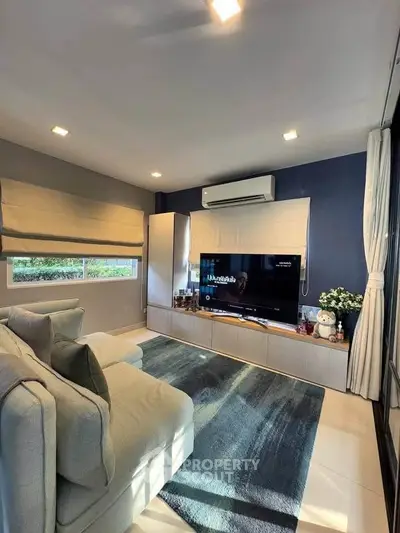 Cozy living room with modern decor, large TV, and comfortable seating, perfect for relaxation.