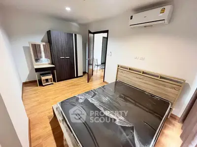 Modern bedroom with wooden flooring and air conditioning in a stylish apartment.