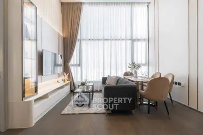 Modern living room with high ceilings and large windows, featuring elegant decor and a cozy seating area.