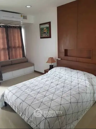Cozy bedroom with modern decor and natural light, featuring a comfortable bed and stylish window seating.