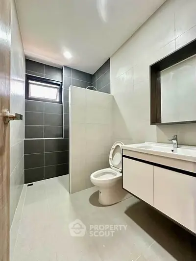 Modern bathroom with sleek design, featuring a spacious shower and contemporary fixtures.