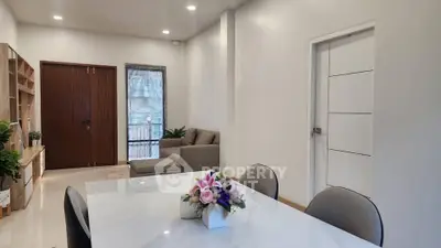 Modern living room with elegant dining area and cozy seating, featuring stylish decor and natural light.