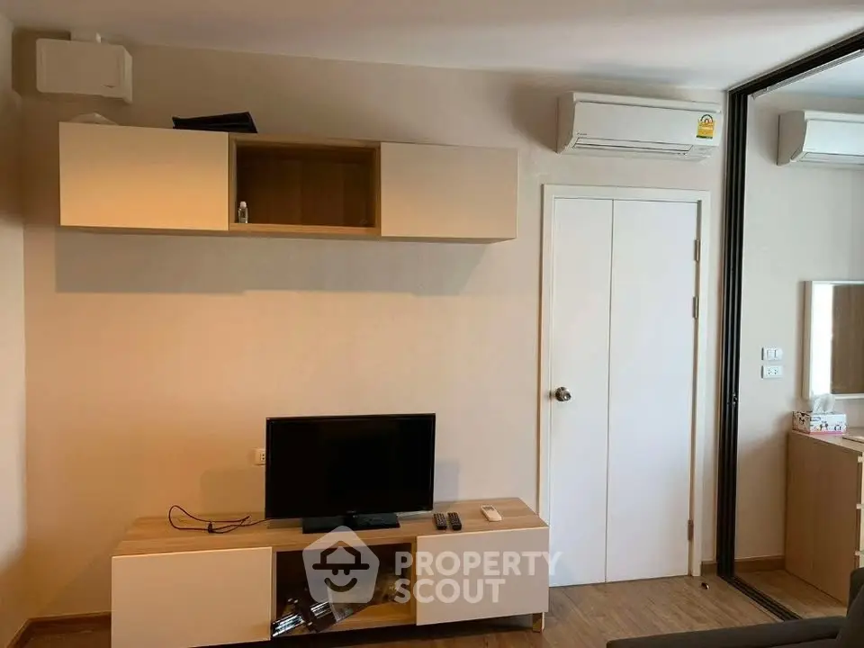 Modern living room with sleek TV unit and air conditioning, perfect for cozy relaxation.