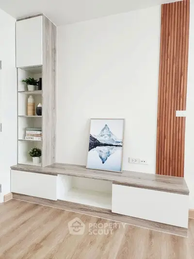 Modern living room with stylish wooden shelving and mountain artwork, perfect for contemporary home decor.