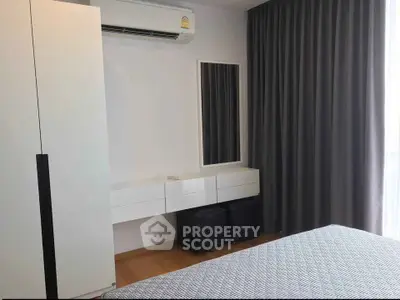 Modern bedroom with sleek furniture and air conditioning in a stylish apartment.