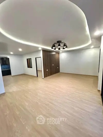 Spacious modern living room with elegant lighting and wooden flooring