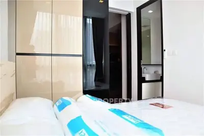 Modern bedroom with sleek wardrobe and cozy bed in a stylish apartment.