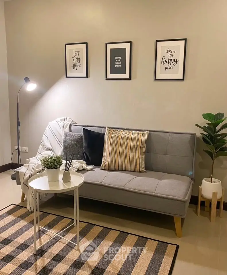 Cozy living room with stylish decor, featuring a modern sofa, chic wall art, and a warm floor lamp.