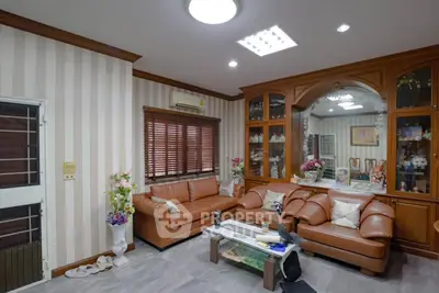 Spacious living room with elegant leather sofas and wooden cabinetry