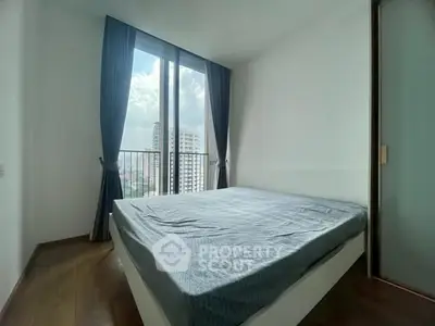 Bright bedroom with large window and city view in modern apartment