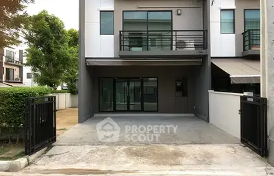 Modern townhouse exterior with gated driveway and balcony