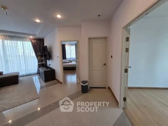 Spacious apartment interior with living room and bedroom view, featuring modern decor and natural light.