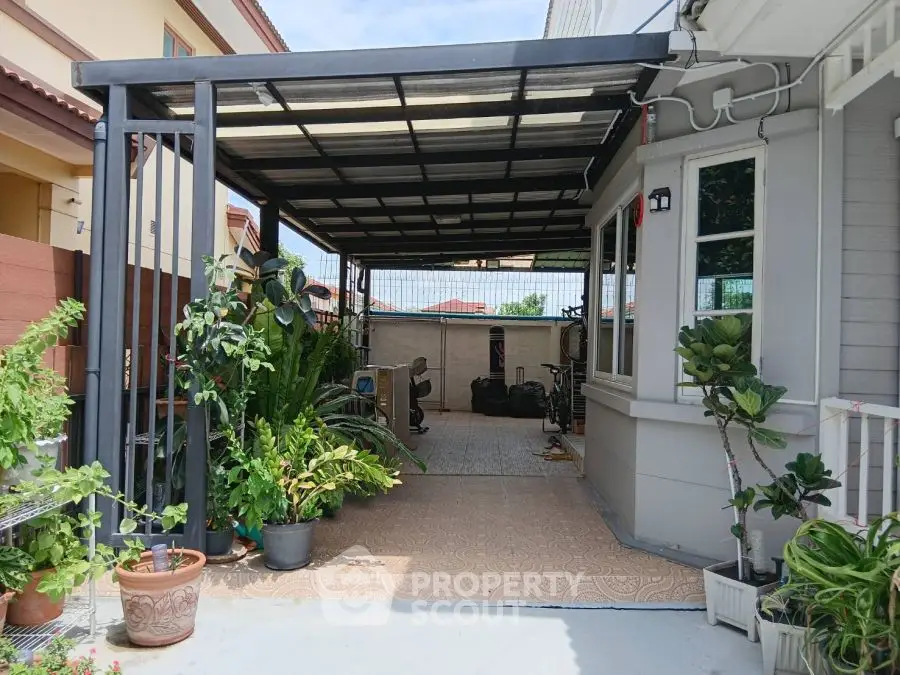 Charming covered patio with lush greenery and tiled flooring, perfect for relaxation and outdoor gatherings.