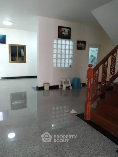 Spacious interior with polished floors and wooden staircase, ideal for modern living.