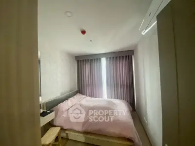 Cozy bedroom with soft pink bedding and modern decor, perfect for relaxation.