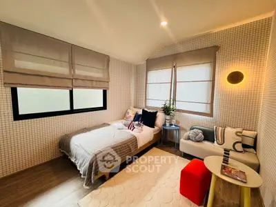 Cozy bedroom with modern decor, featuring a comfortable bed, stylish seating, and soft lighting.