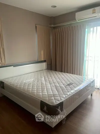 Spacious bedroom with large bed and natural light from window