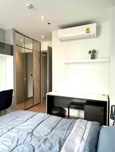 Modern bedroom with sleek design, featuring built-in wardrobe and air conditioning unit.