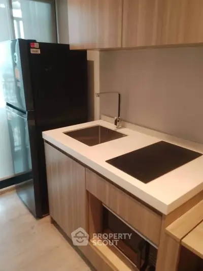 Modern kitchen with sleek appliances and wooden cabinetry, featuring a compact design ideal for urban living.