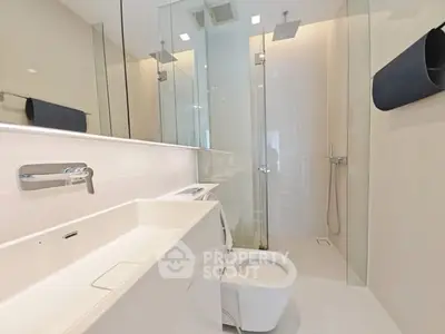 Modern minimalist bathroom with sleek fixtures and glass shower enclosure