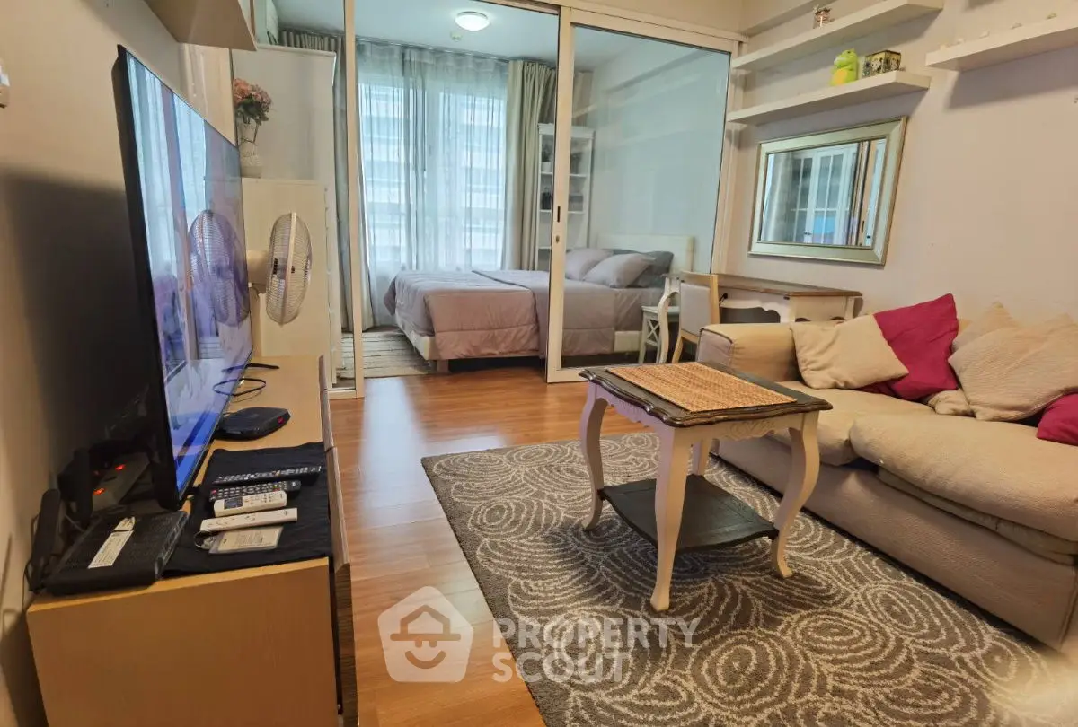Cozy living room with modern decor and view into a stylish bedroom