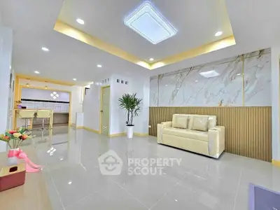Spacious modern living room with elegant marble accents and cozy seating area.
