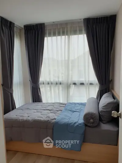 Cozy bedroom with large windows and elegant curtains, perfect for natural light lovers.
