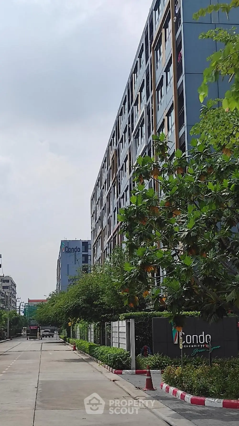 Modern condominium building with lush greenery and spacious driveway