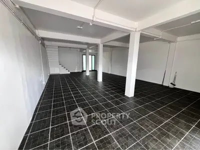 Spacious open-plan interior with tiled flooring and modern design, ideal for versatile use.