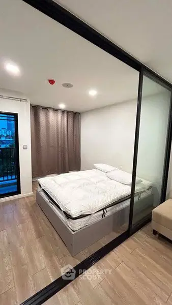 Modern bedroom with glass partition and cozy decor in urban apartment