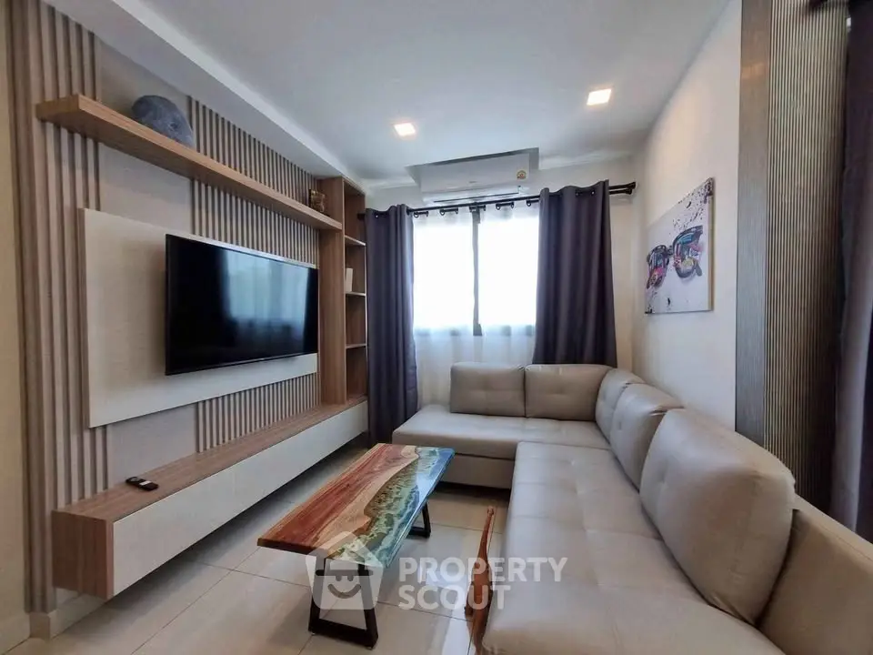 Modern living room with stylish furniture and wall-mounted TV, featuring elegant decor and natural light.