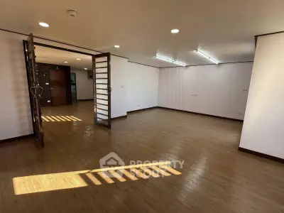 Spacious living room with wooden flooring and ample natural light