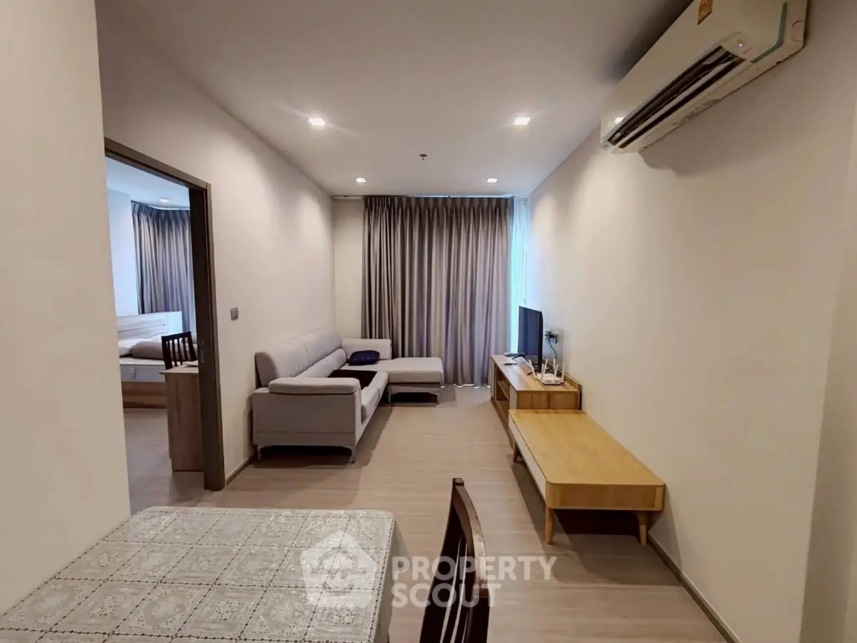 Modern living room with sleek furniture and air conditioning in a cozy apartment setting.