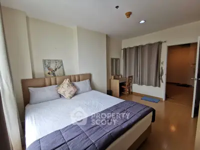 Spacious bedroom with modern decor and natural light, featuring a comfortable bed and study area.