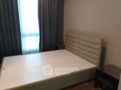 Spacious bedroom with modern bed frame and elegant curtains