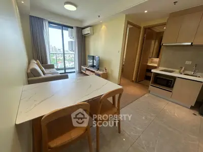 Modern open-plan living room with kitchen and city view balcony in a stylish apartment.