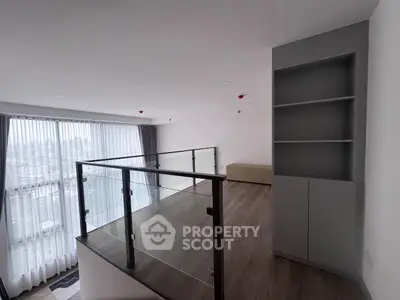 Spacious modern living room with glass railing and large windows offering city views.