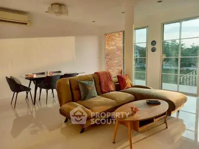 Spacious living room with modern furniture and large windows offering natural light and scenic views.