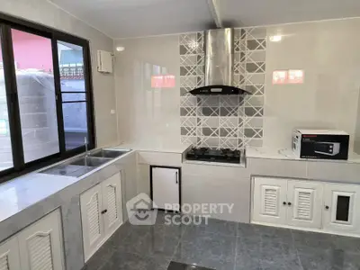 Modern kitchen with sleek design, featuring gas stove and ample storage space.