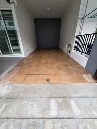 Spacious tiled entrance area with modern design and glass sliding doors