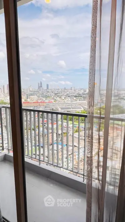 Stunning cityscape view from high-rise balcony with glass doors and sheer curtains.
