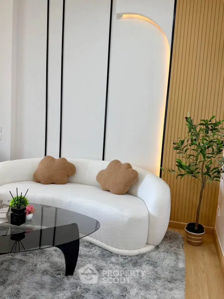 Modern living room with stylish white sofa, plush rug, and elegant decor