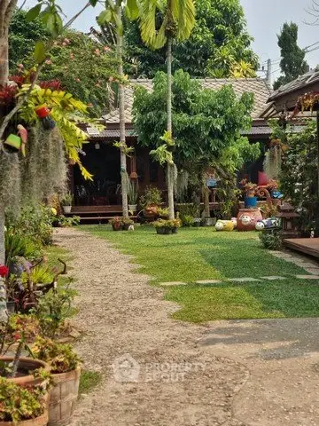 Charming garden view with lush greenery and rustic house exterior, perfect for serene living.