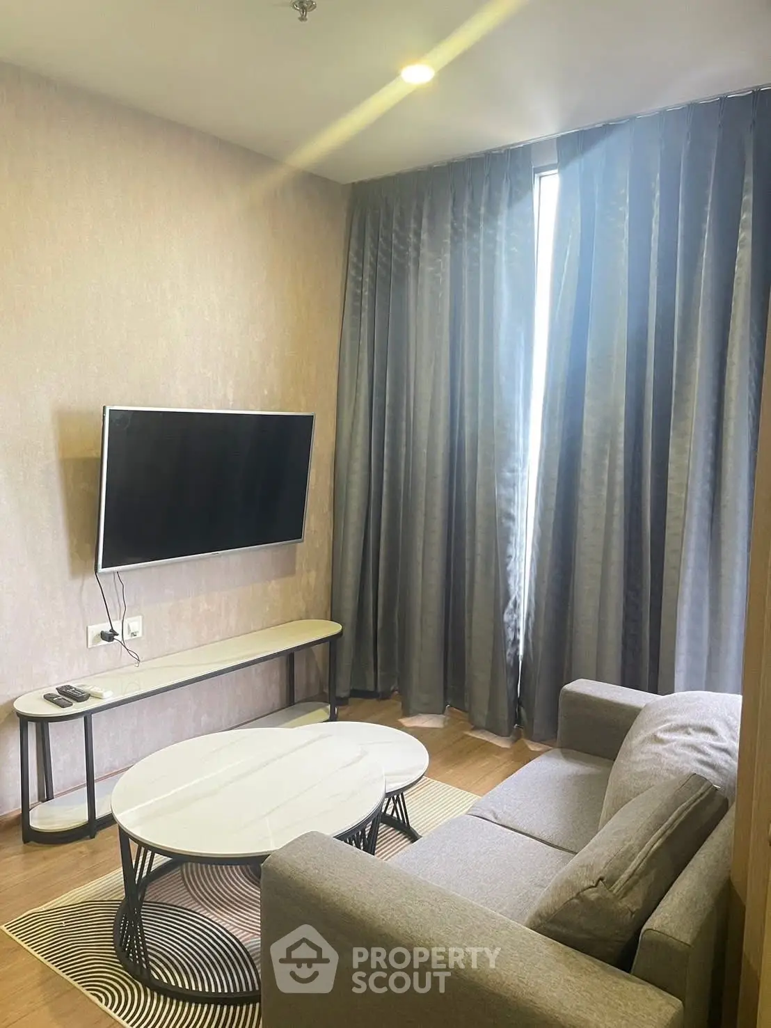 Modern living room with sleek furniture and wall-mounted TV, perfect for cozy relaxation.