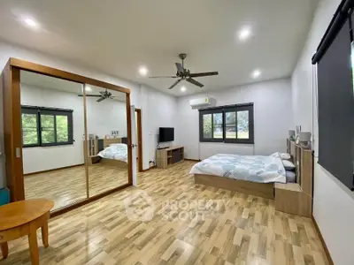 Spacious bedroom with mirrored wardrobe and modern decor