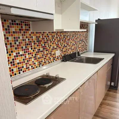 Modern kitchen with vibrant mosaic backsplash and electric stove