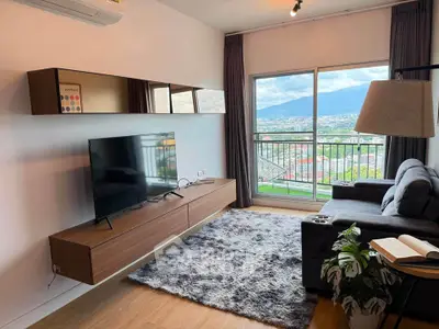 Modern living room with mountain view, featuring sleek furniture and large TV, perfect for relaxation.