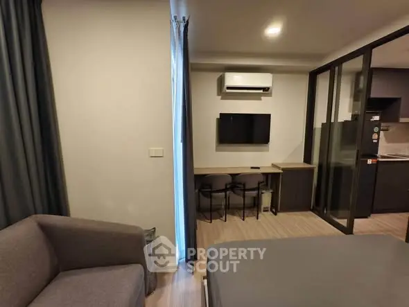 Modern studio apartment with cozy living area and sleek kitchen design.